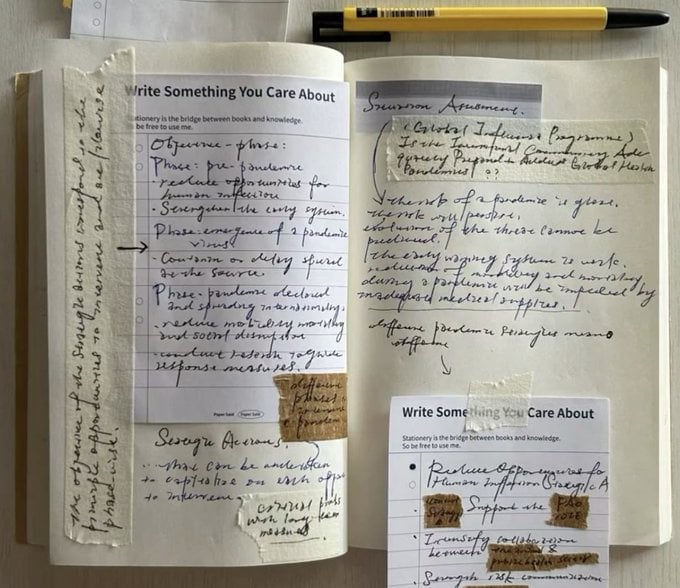 An open handwritten journal on a wooden desk, pages filled with cursive writing